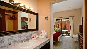 Un bagno con un grande specchio, un lavandino e una zona doccia.