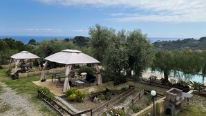 Vista di un giardino con posti a sedere all'aperto e uno specchio d'acqua sullo sfondo.