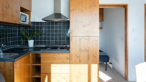 Una cucina moderna con mobili in legno, un fornello a gas e un forno a microonde.