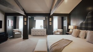 A hotel room with a large bed, two armchairs, a dresser, and a television. - The Winston Solvang (Solvang)