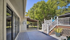 A wooden deck with a covered area, a staircase, and a potted plant. - Pet-Friendly Oasis w/ Deck & Fire Pit in Bokeelia! (Bokeelia)