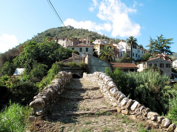 Un sentiero in pietra conduce a un pendio con edifici tradizionali.