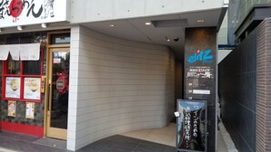 Un restaurante con fachada de baldosas y un cartel.