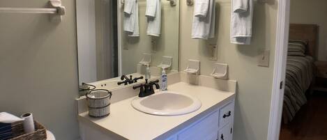 A bathroom with a white sink, a mirror, and a towel rack.