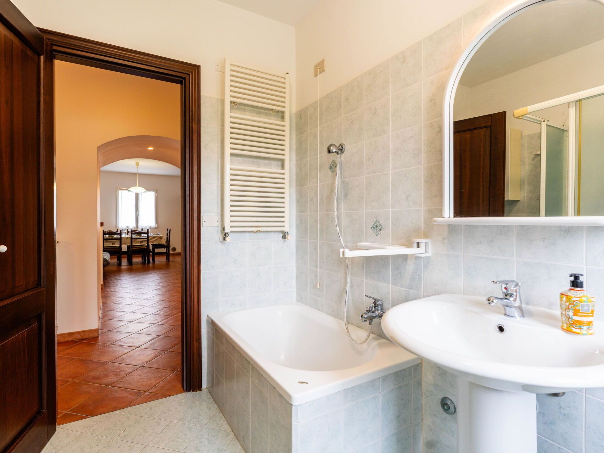 Een badkamer met een bad, een wastafel en een douche.