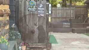Une porte en bois rustique, ornée de panneaux indiquant « Défense de passer » et « Bienvenue chez nous, où nous soutenons les Marines ».