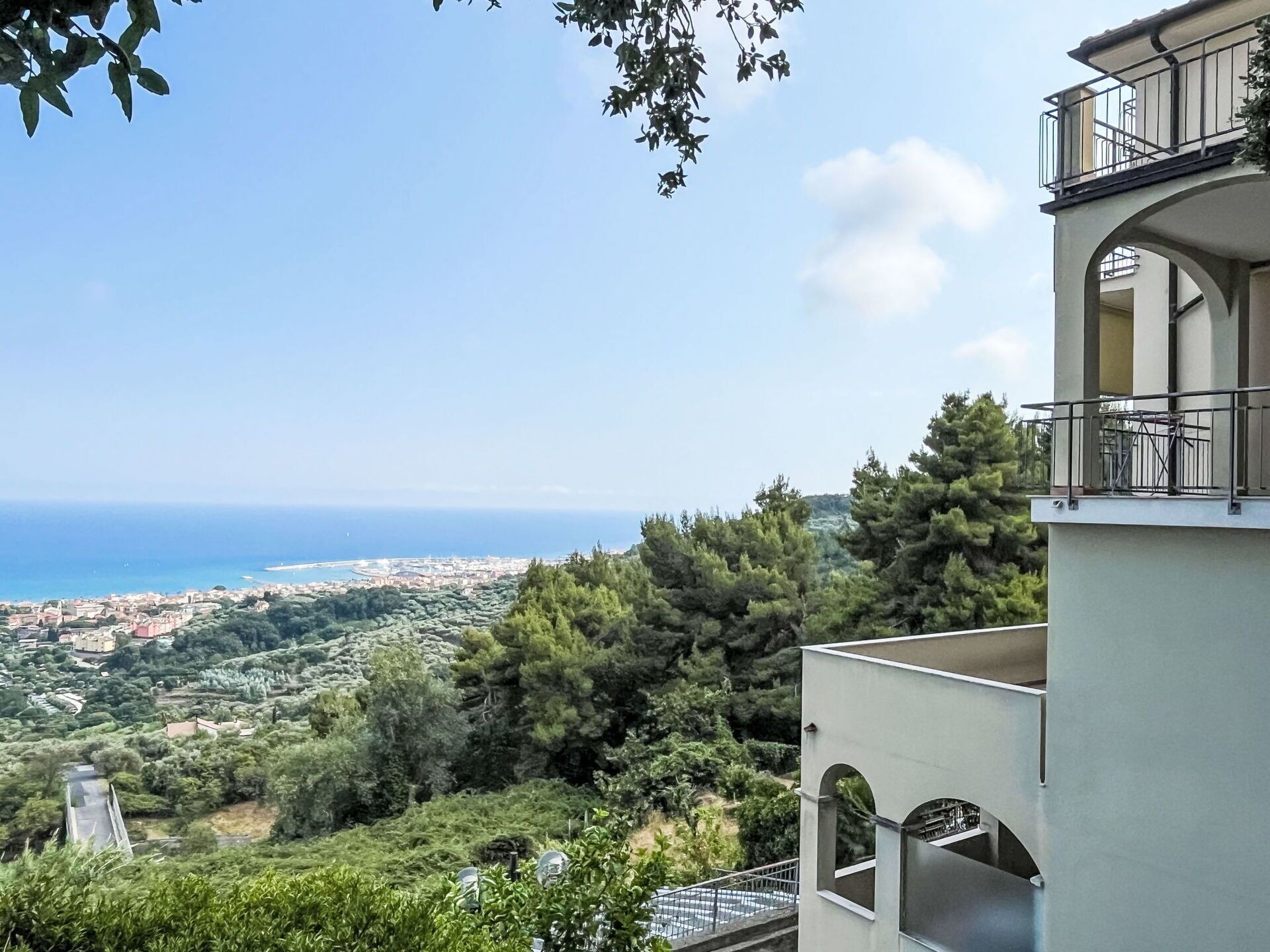 A coastal view with a building featuring balconies and a clear sky.