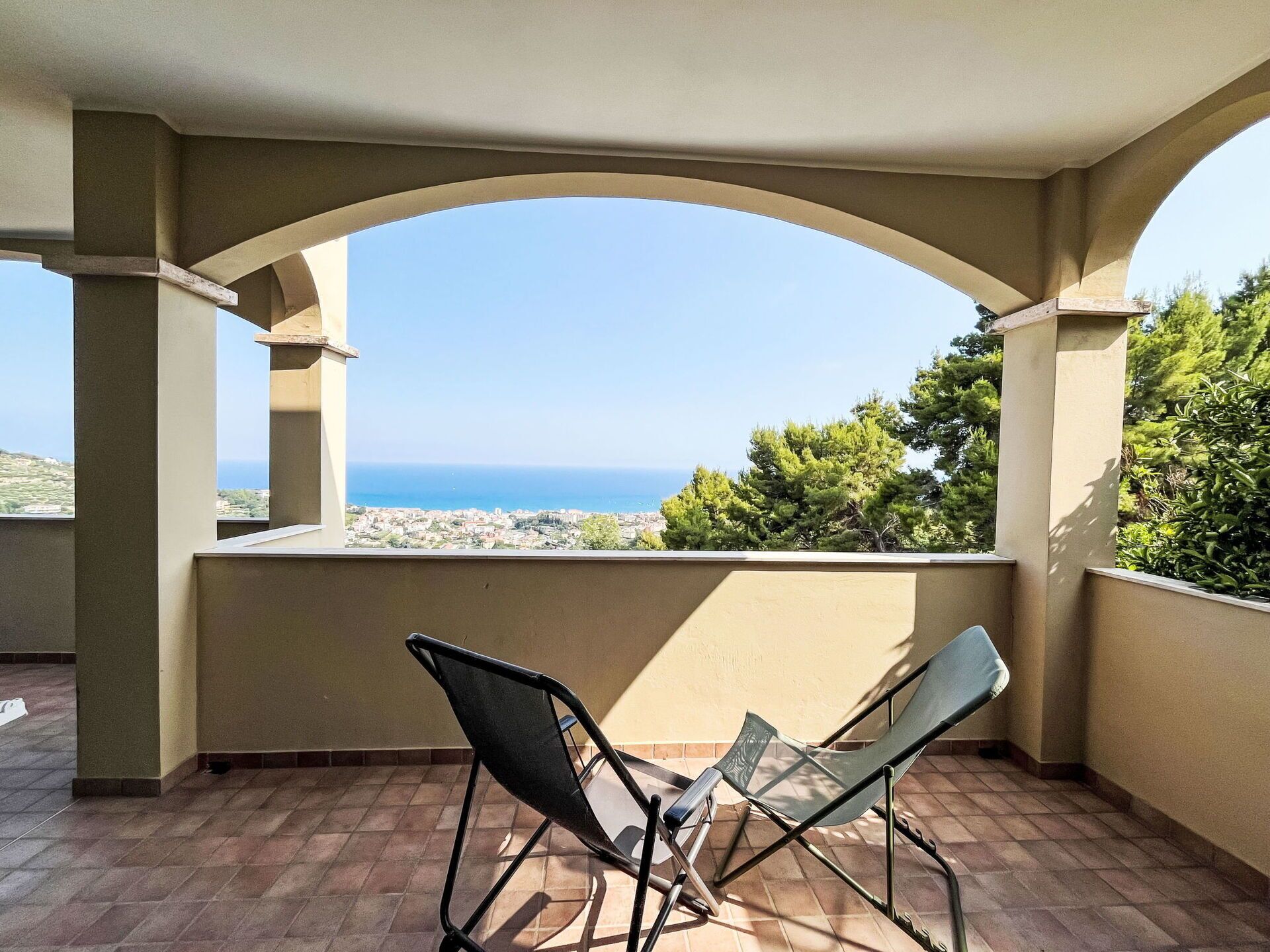 Un balcon avec deux chaises et vue sur la mer.