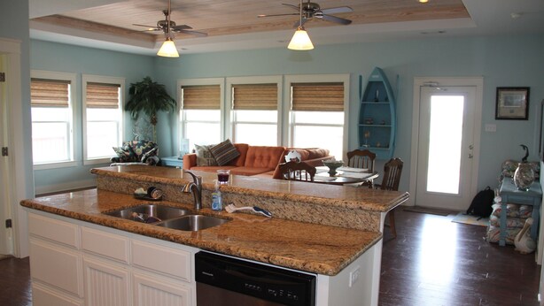A spacious kitchen with granite countertops, a dishwasher, and a dining area with a table and chairs. - Shore Fun! 3/2 Beachhouse, Holiday Beach Subdivision, Close to Everything! (Port Bolivar)