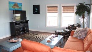 A living room with a television, sofa, coffee table, and decorative pillows. - Shore Fun! 3/2 Beachhouse, Holiday Beach Subdivision, Close to Everything! (Port Bolivar)