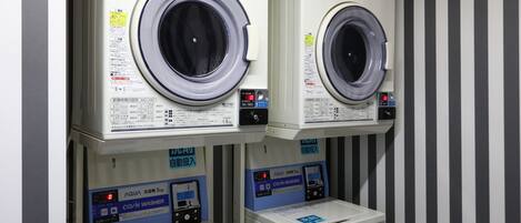 Two stacked washing machines with control panels below them.