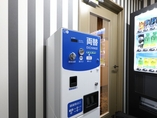 A vending machine with a blue and white color scheme, featuring a screen displaying various beverage options.