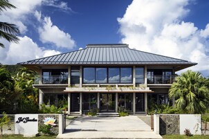 Un edificio moderno con techo plano, amplias ventanas y un cartel que dice "Sky Sanctuary".
