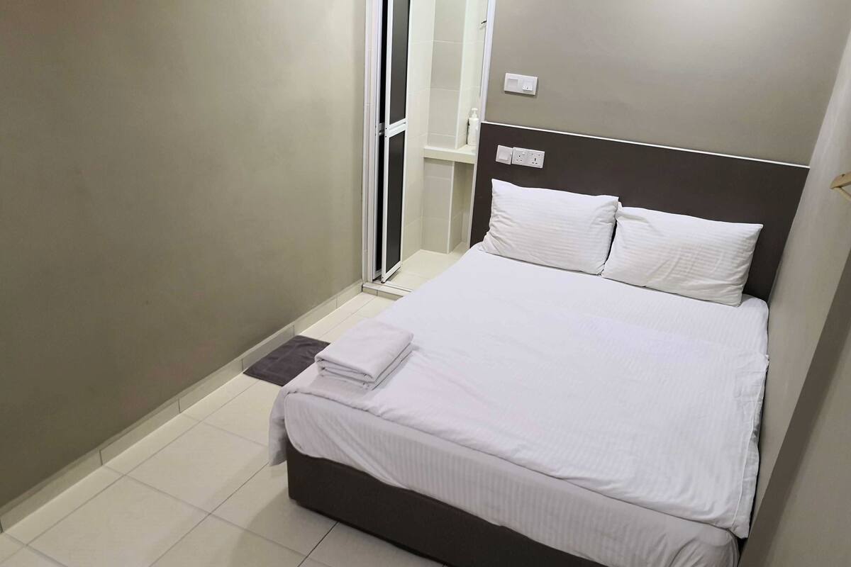 Une chambre à coucher avec un lit, une table de chevet, une porte et une serviette.