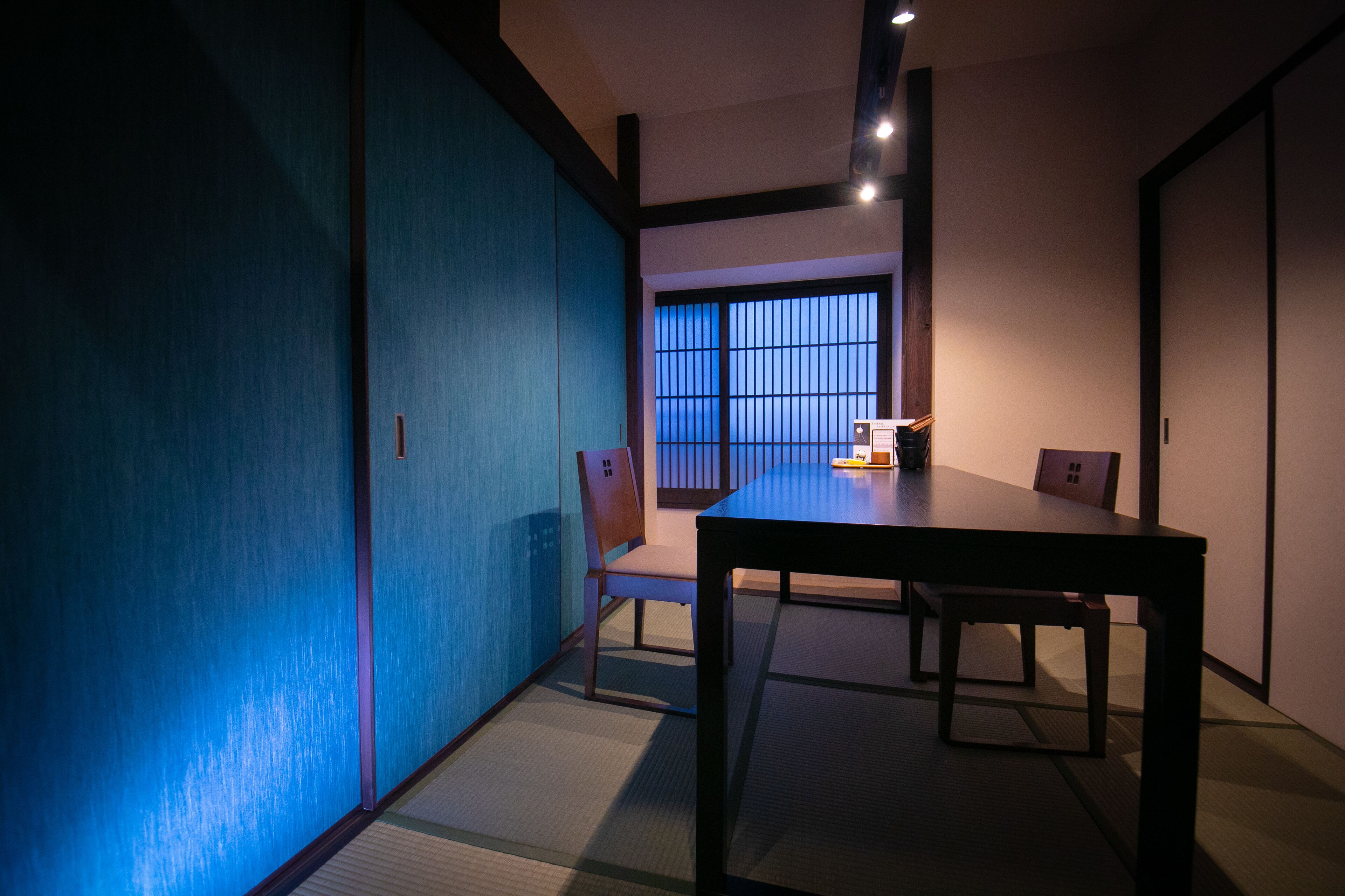 Ein traditioneller japanischer Raum mit Tatami-Böden, einem niedrigen Tisch und Schiebetüren.