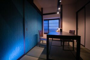 Perinteinen japanilainen huone, jossa on tatamimatto, matala pöytä ja liukuvat ovet.