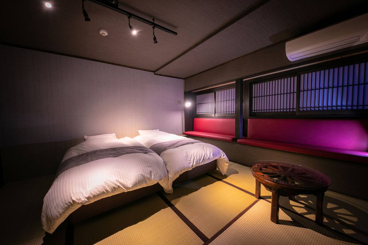 A neatly arranged bedroom with a bed, a small table, and a window with a view.