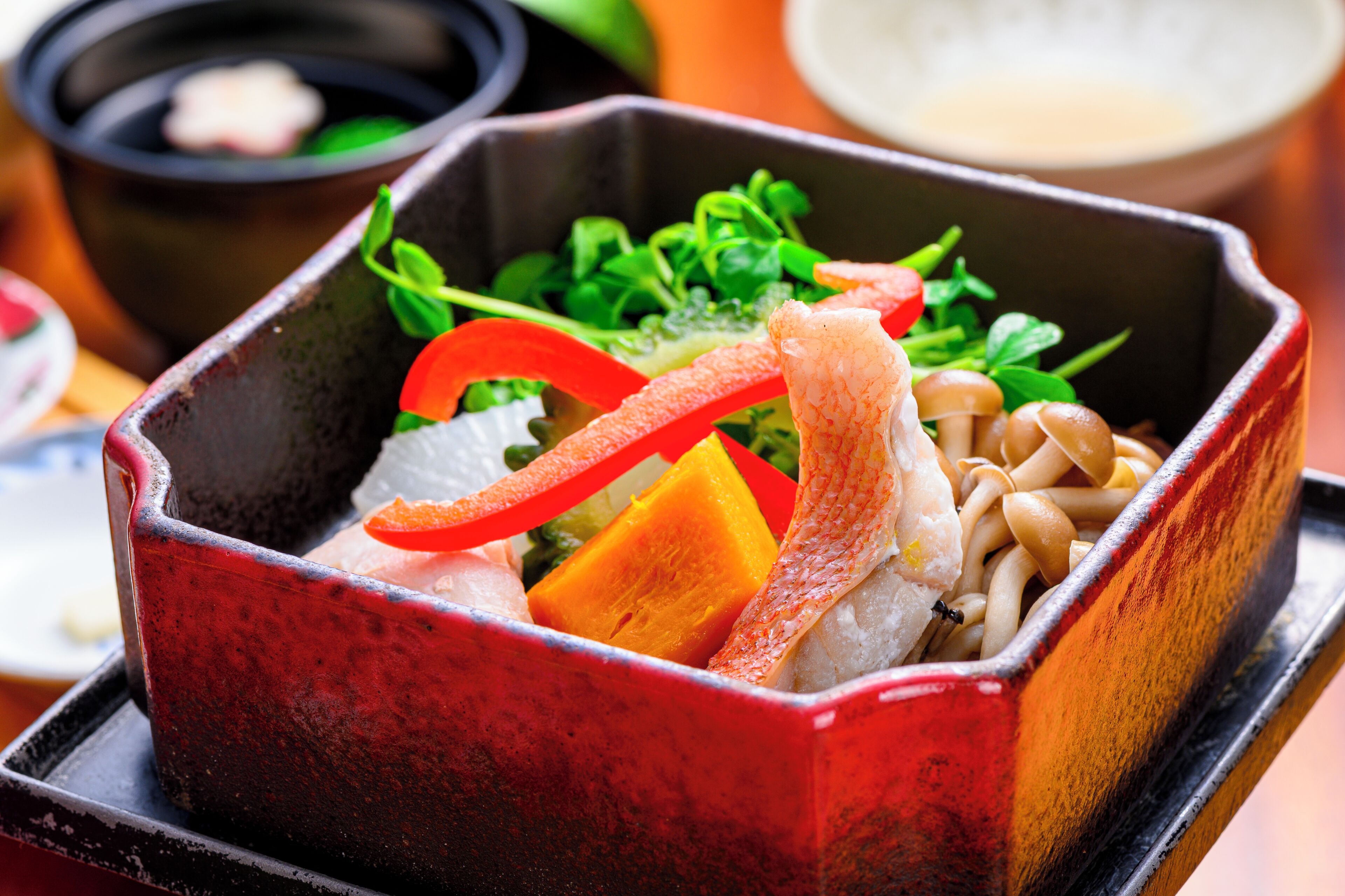 Una caja bento japonesa tradicional con diferentes alimentos.