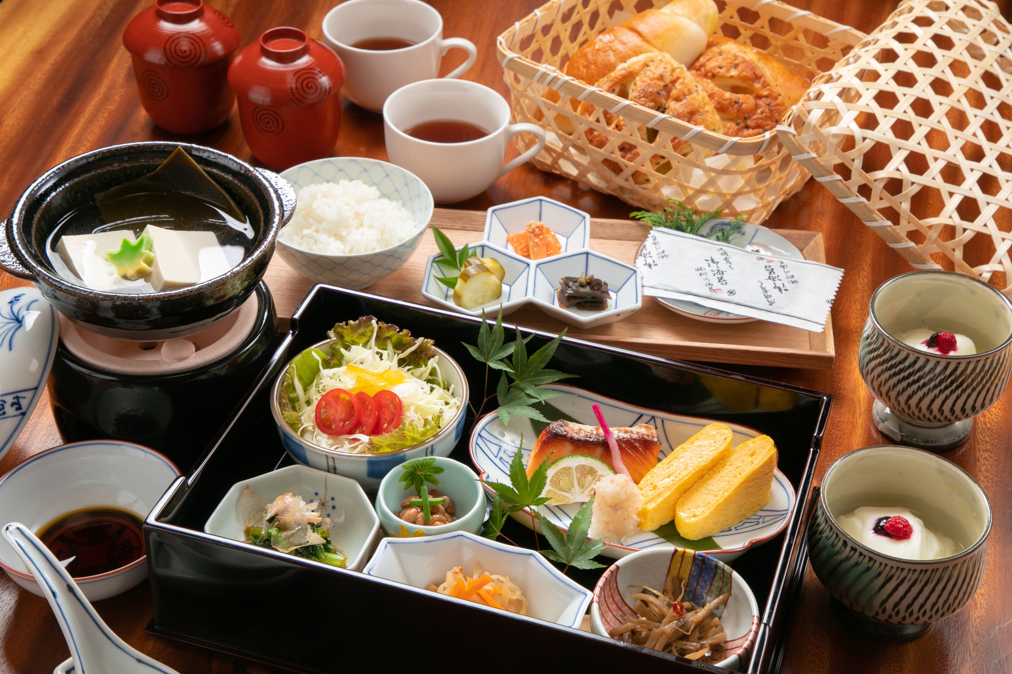 Un repas japonais traditionnel, composé de différents plats, notamment des sushis, du riz et des légumes marinés, présentés sur un plateau.