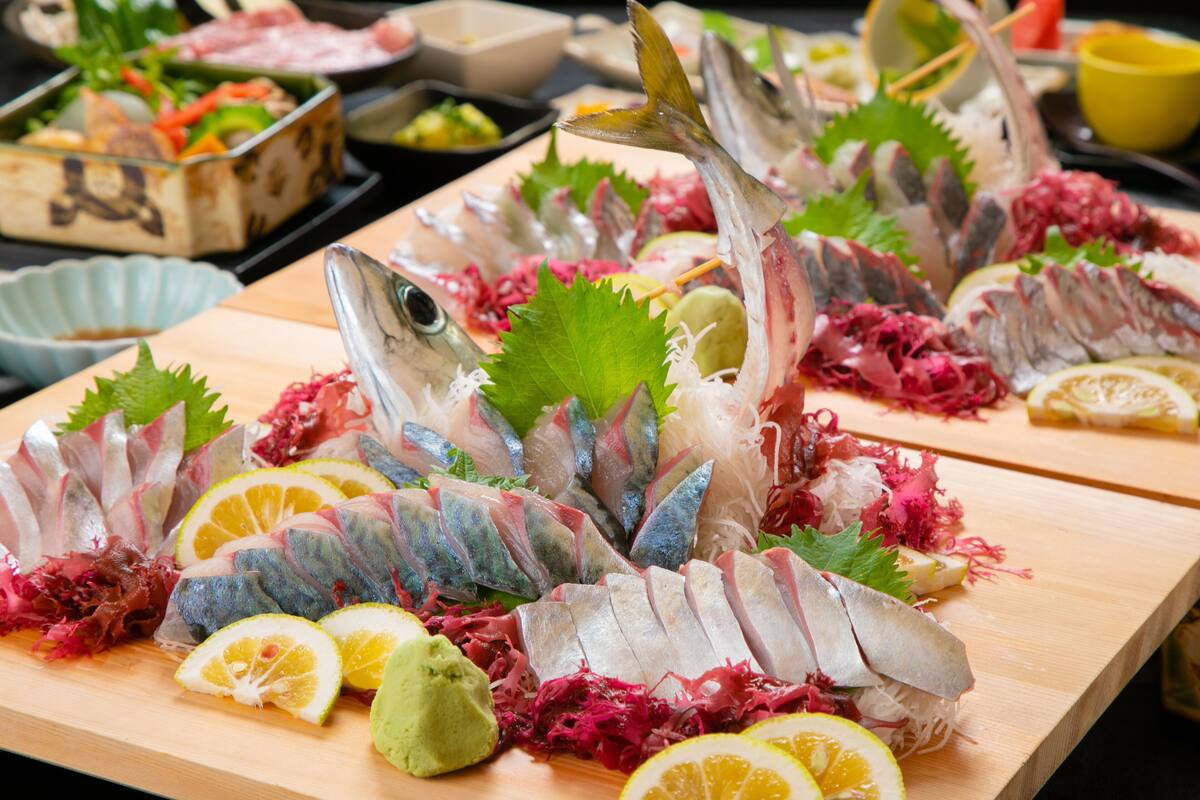 A wooden table with various seafood dishes, including fish and garnishes.