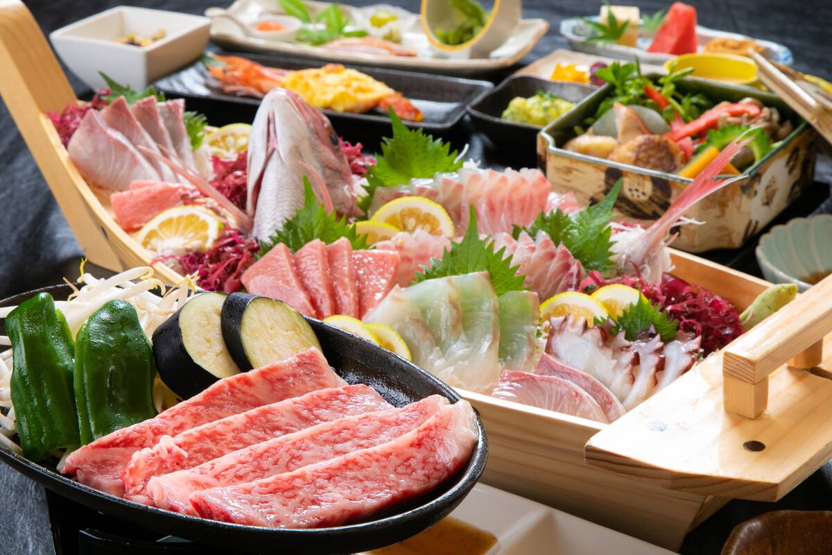 A variety of sushi and sashimi dishes arranged on a wooden table.
