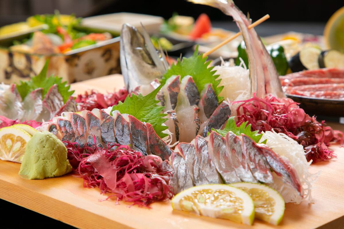 A variety of seafood including fish and roe, garnished with vegetables and citrus slices.