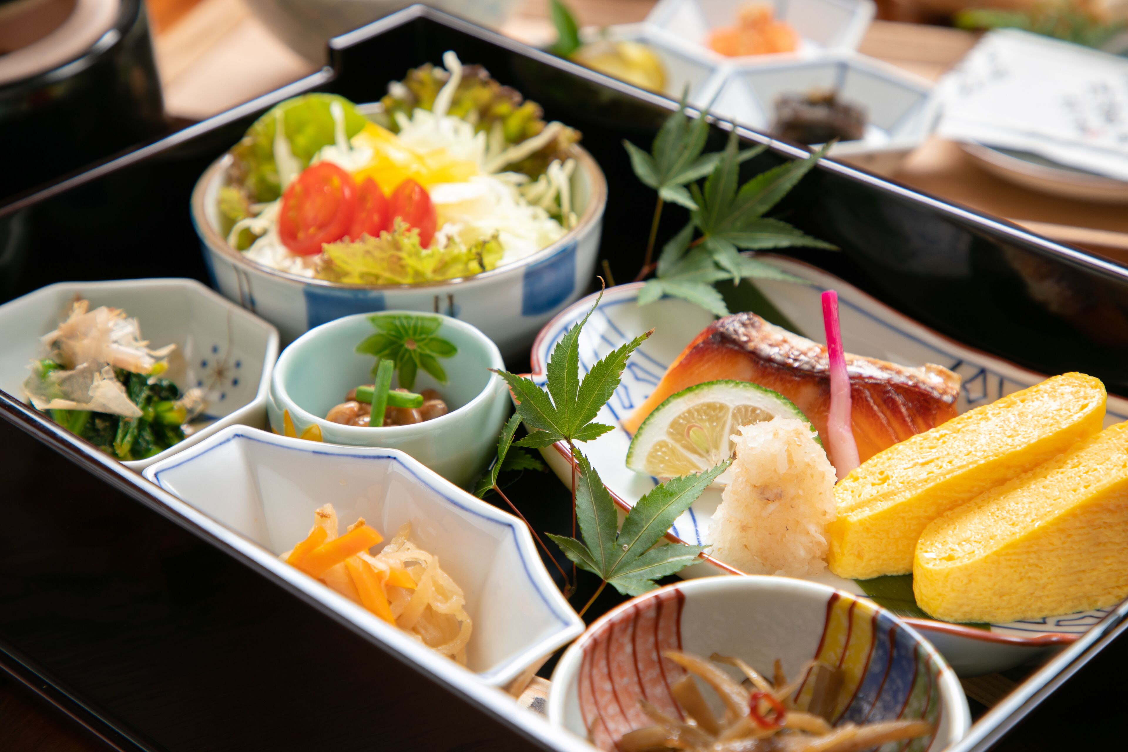 A traditional Japanese meal with various dishes including sashimi, rice, and vegetables.
