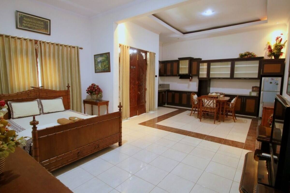 A hotel room with a bed, a dining table, and a kitchen area.