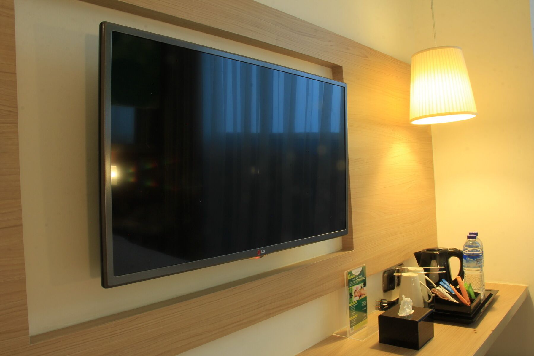 A flat-screen TV mounted on a wall with a wooden panel design.
