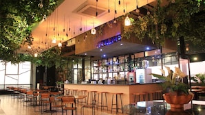 Zona de bar con mostrador, sillas y lámparas colgantes.
