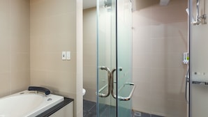 Une salle de bain moderne avec une douche à parois de verre, une baignoire et des toilettes.