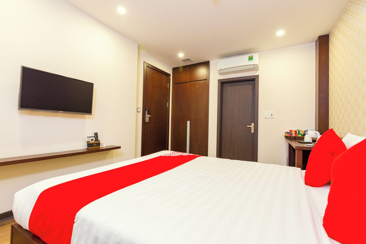 Une chambre d’hôtel équipée d’un lit, d’un téléviseur fixé au mur, d’une armoire et d’un appareil de climatisation.