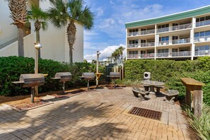 Enjoy al fresco dining and cooking at this outdoor patio, featuring a central seating area and barbecue grills.