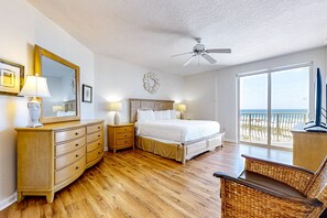 Relax in comfort with a large bed, dresser, and nightstands, plus a wicker chair and TV for entertainment.