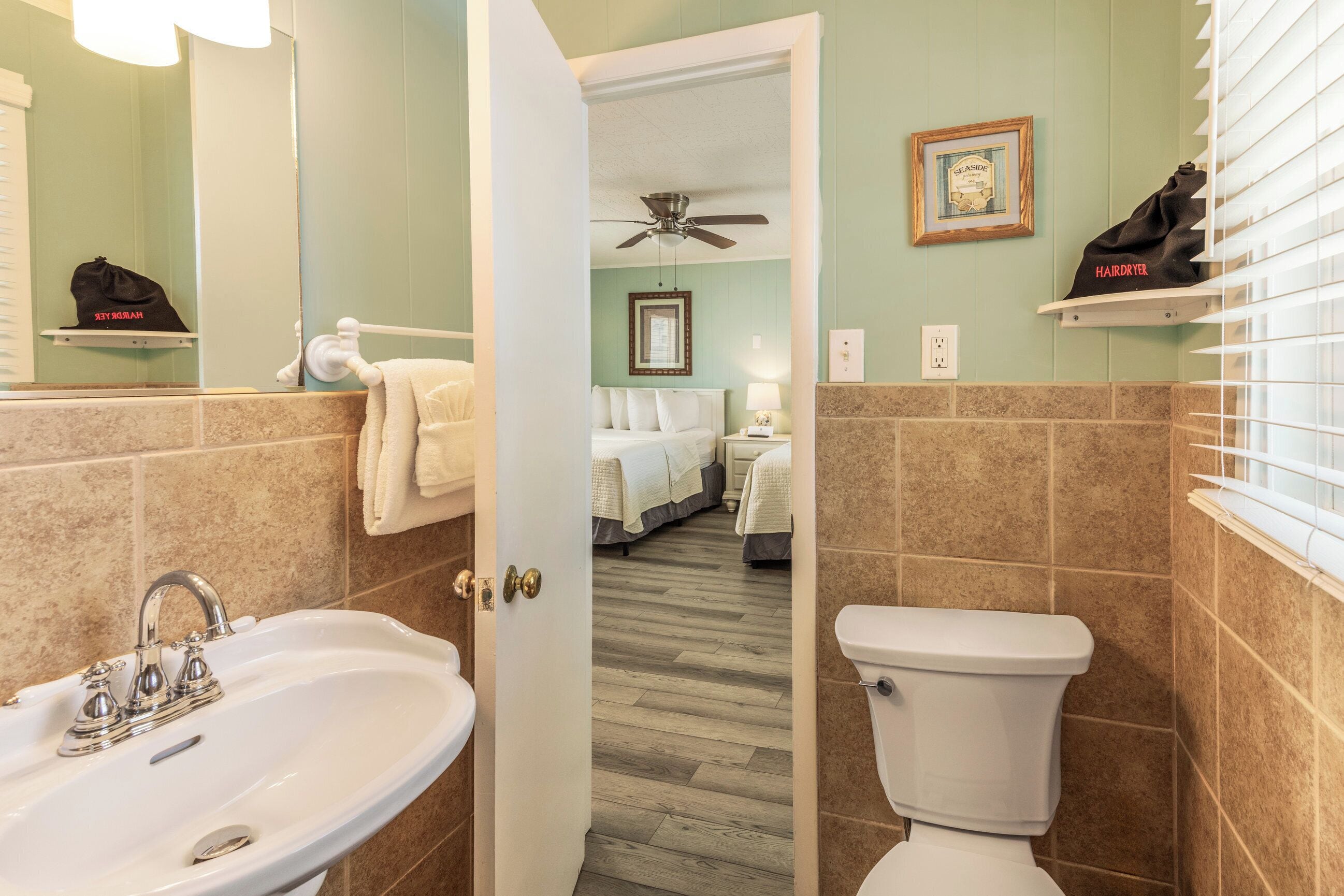 A bathroom with a sink, toilet, and a shower area.