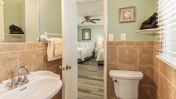 A bathroom with a sink, toilet, and a shower area.
