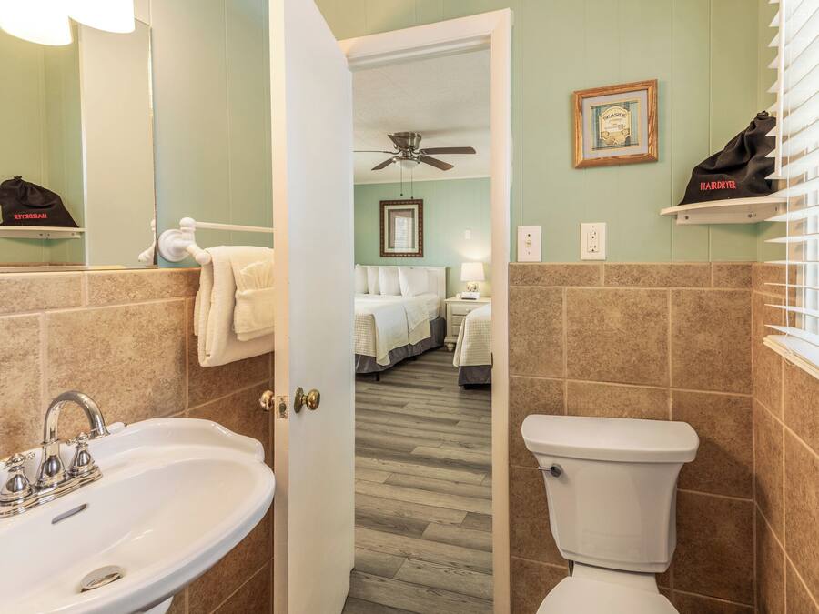 A bathroom with a sink, toilet, and a shower area.