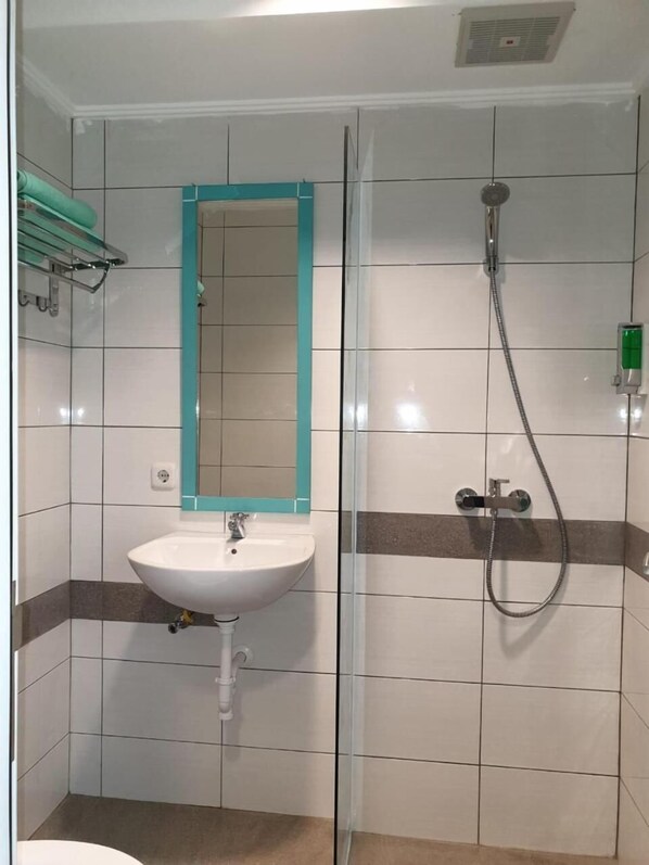 A bathroom with a sink, mirror, and shower. - Aruuman Hotel Simpanglima Semarang (Semarang)