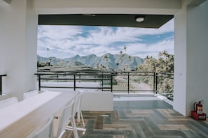 A modern dining area with a view of mountains and palm trees. - Ruili Tea Villa (Meishan)