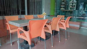 En matplats med orangefärgade stolar och ett rektangulärt bord.