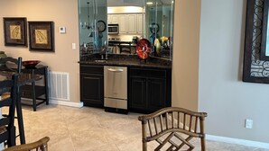 A kitchen with a dishwasher, a microwave, and a large mirror.