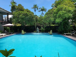 Outdoor pool, pool umbrellas, sun loungers - Sanur Agung Suite (Denpasar)