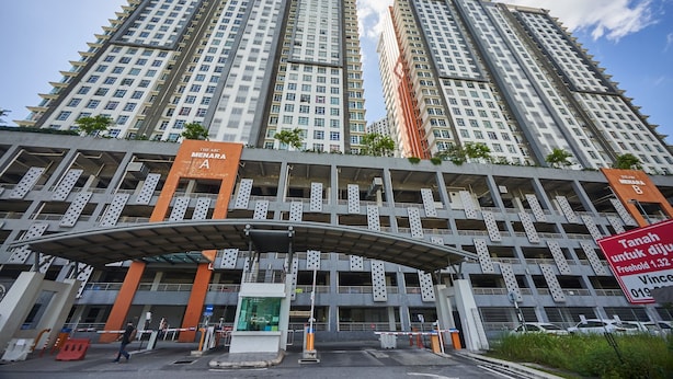 A high-rise building with multiple floors, a covered entrance, and a sign indicating a freehold property. - OYO Home 89748 Classic 3 Br The Arc (Cyberjaya)