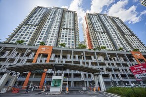 Un immeuble de grande hauteur, doté de plusieurs étages, d’une entrée couverte et d’une enseigne indiquant qu’il s’agit d’une propriété en pleine propriété.