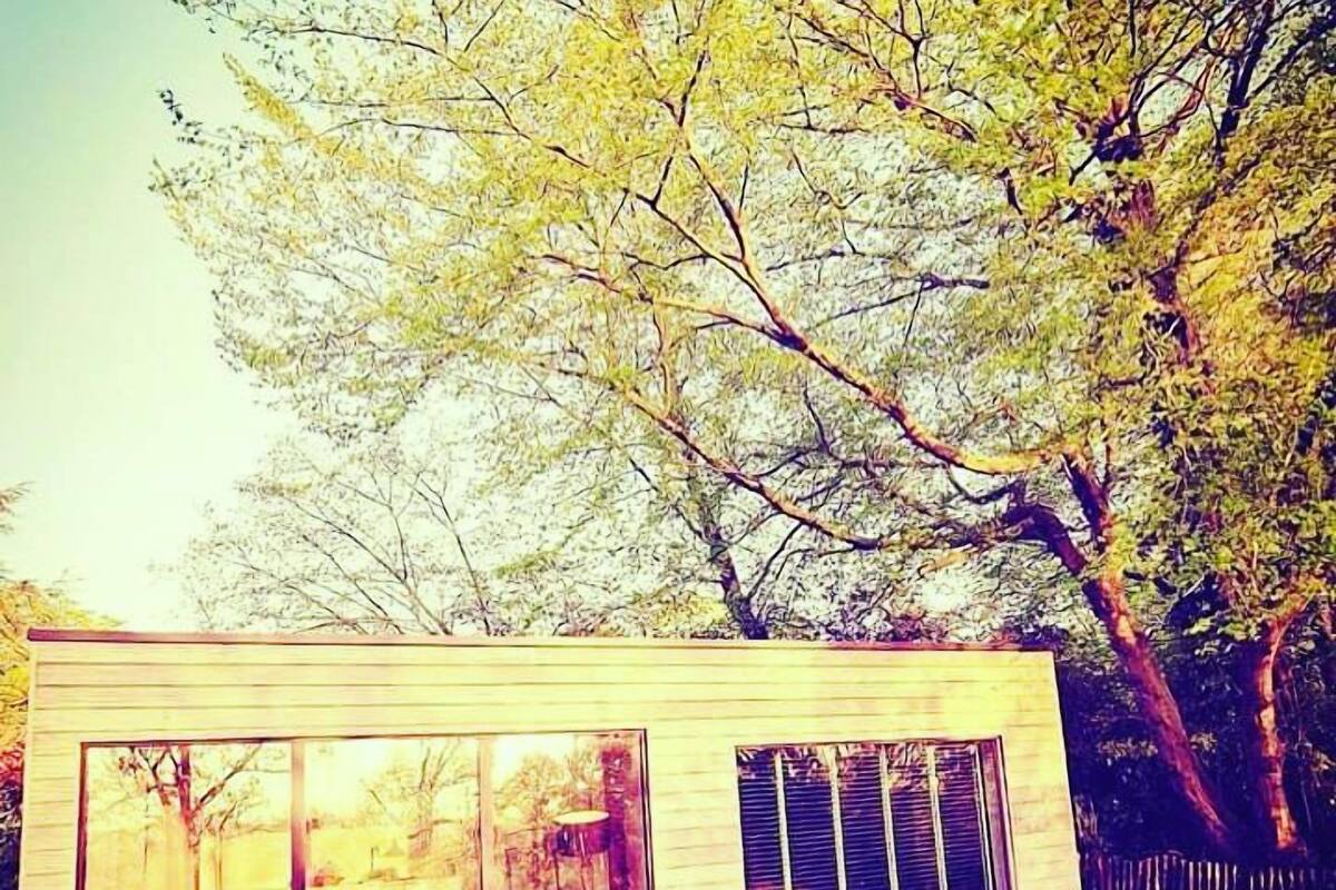 A modern house with large glass windows and a wooden deck.