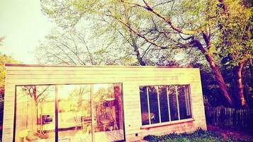 A modern house with large glass windows and a wooden deck.