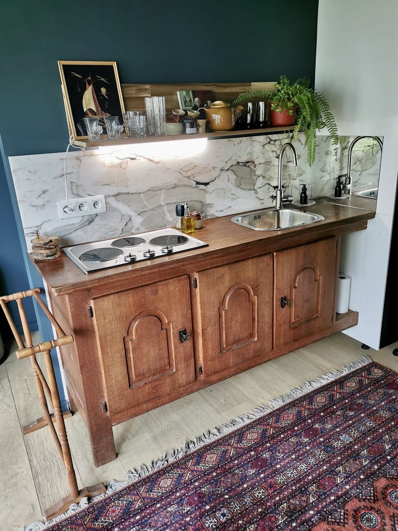 A kitchen with a marble backsplash, wooden cabinets, a double sink, and a built-in stove.