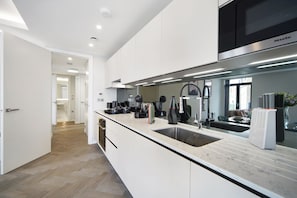 Enjoy cooking in this well-lit kitchen with sleek cabinetry, a large sink, and microwave.