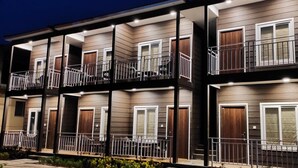 Un immeuble résidentiel à plusieurs étages, doté de balcons, de portes en bois et d’un design moderne.