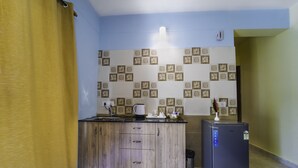 Una cocina pequeña con un mueble de madera, un refrigerador y un salpicadero de azulejos.
